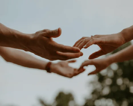 Deux personnes face à face qui se prennent les mains